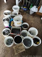 Overall view of 20 containers of assorted nails, screws, bolts, and hardware on shed floor