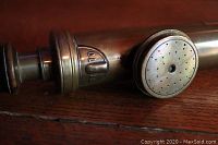 Close-up of brass air pump nozzle with perforated circular tip and '10' marking