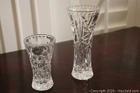 Two Lenox crystal vases of different sizes placed on a dark wooden surface showing full height and pattern detail