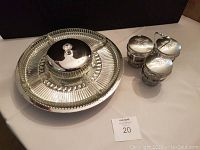 Glass serving tray rotating with 5 glass compartments and central metal lid seen from above