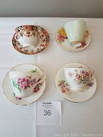 Top view of 4 fine bone china cups and their matching saucers, showing different floral and ornamental patterns