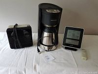 Full view of the lot showing the Braun electric heater, coffee maker, digital weather station, and remote sensor.