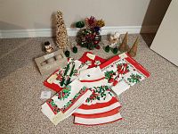 Full view of all Christmas items including linens, figurines, cone trees, and other decorations arranged on carpet.