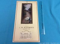 Photo of the entire 1928 calendar sheet showing the pastoral image, dates for February, and contact information from C. W. McRoberts of Granton, Ont.