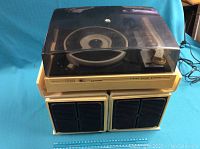 Photo showing the vintage Sears stereo record player with its detachable speakers and the protective dust cover in place.