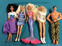 Five dolls on blue background showing different styles and outfits including mermaid doll and male doll.