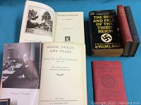 Five vintage hardcover books on blue cloth background. Titles include works by Churchill and Dickens, among others.