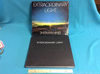 Photo of the book cover and protective dust jacket showing the title 'Extraordinary Light' by Sherman Hines.