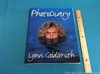 Cover photo of the hardcover book titled 'Photo Diary' by Lynn Goldsmith, showing a man with curly hair partially submerged in water.
