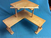 Photo showing full view of the wooden corner shelving unit with a ruler placed on the top shelf for scale.