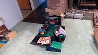 Overview of all board games, poker chip sets, cards, and the Sega Genesis box on carpet floor near fireplace