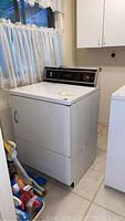 Front and side view of GE electric dryer showing overall condition and placement.