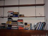 Books stacked on shelves, mostly history and cooking, various sizes and bindings, some tall stacks.