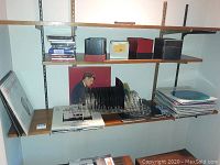 Photo of shelves showing racks with vinyl records, albums, and some box sets with 45 rpm singles.