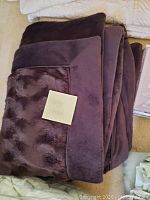 Large brown throw blanket folded with a note that says 'large throw'