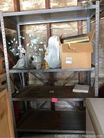 Full view of steel frame shelving unit with items on shelves to show scale and condition