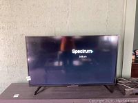 Front view of powered-on screen displaying Spectrum logo and time