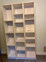 Front view of tall cubby storage unit showing multiple open shelves with wear and marks.