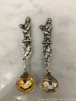 Top down view of both small silver decorative spoons showing the gold and silver toned bowls
