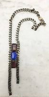 Full length view of necklace showing chain and three large glass stones arranged vertically.