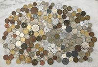 Top-down photo showing a large assortment of 188 coins in various colors and sizes spread out on a white surface.
