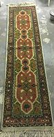 Full view of the entire runner rug on concrete floor showing its pattern and colors.