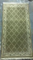 Full view of rectangular beige and light brown Nealane Belgium rug with lattice pattern and floral border.