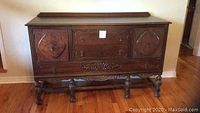 Front view of carved wood sideboard showing drawers and doors