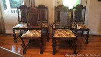 Front view of six carved dark wood chairs grouped
