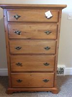 Front view of pine tall boy dresser showing all five drawers and metal handles