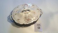Top view of antique Johnson Brothers England serving dish with lid, floral pattern and gold handles visible