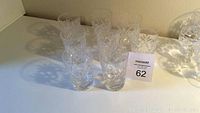 Eight Birks Georgian crystal juice glasses arranged in rows on a white surface showing cut pattern and overall design