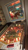 Front angled view showing illuminated playfield and backglass with Corral title