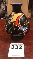 Black ceramic vase with colorful abstract pattern, front view