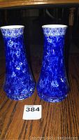 Pair of blue Shelley vases shown side by side on wooden surface.