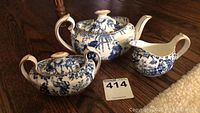Full set showing teapot, creamer, and sugar pot with blue oriental patterns.