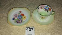 Three piece Shelley tea cup set comprising cup, saucer, and small dish with floral pansy design.