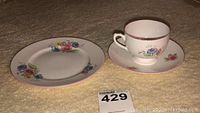 Three piece Shelley tea set comprising tea cup, saucer, and dish on a textured surface.