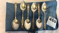 Six spoons laid on blue cloth