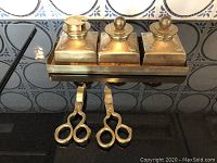 Photo of the brass desk set showing three lidded containers on the tray with two pairs of candle snuff scissors in front.