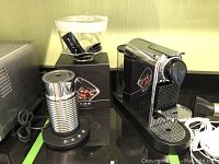 Nespresso Essenza Mini machine with Aeroccino milk frother and boxed Nespresso View capsules displayed on countertop.