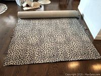 Wide view of rolled wool carpet with animal print design exposing most of the pattern and size.