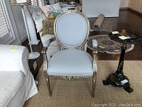 Front view of armchair showing carved frame and upholstery