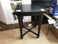 Front angled view showing black painted wooden side table with twisted rope design legs and crossbar, square top surface.