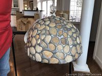 Front view of dome-shaped stone mosaic hanging light