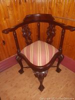 Front view showcasing carved backrest, armrests, and upholstery