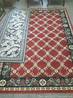 Photo showing the red carpet and one black runner laid across the carpet, highlighting contrasting patterns and colors.