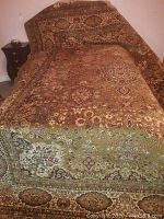 Full view of rug draped over bed showing overall pattern and size