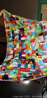 Full view of a handmade quilt with colorful patchwork squares and border.