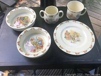 Full set of 5 pieces including 2 porringer bowls, 1 plate, and 2 mugs on black surface.